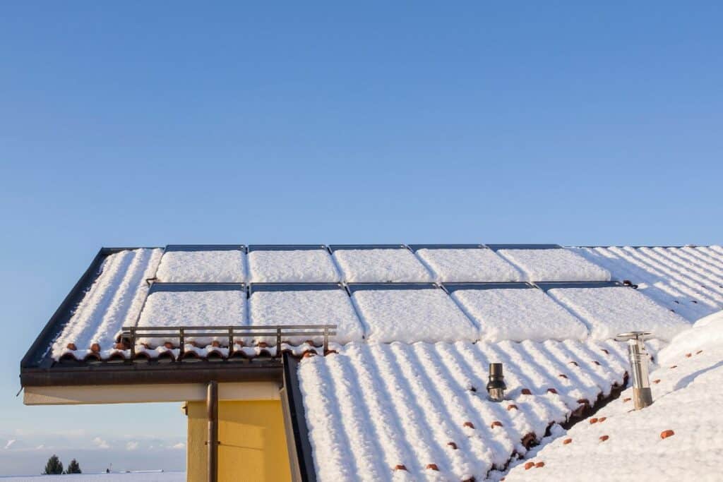 Lots of snow on a roof full of solar panels